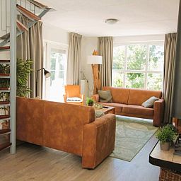 Cozy living room of Holiday home F 681 in De Cocksdorp, Texel with comfortable seating area and large windows for a beautiful view.