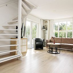 Lichte woonkamer van Vakantiehuis F 759 in De Cocksdorp, Texel, met moderne inrichting en uitzicht op de groene omgeving.
