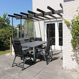 Zonnig terras met moderne meubels bij Vakantiehuis E 413 in De Cocksdorp, Texel, ideaal vakantiehuis op de Waddeneilanden.