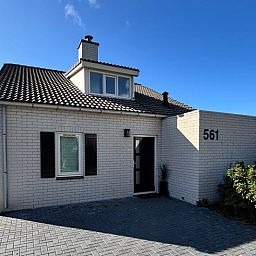 Ferienhaus F 561 in De Cocksdorp, Texel, schoene weisse Fassade mit moderner Ausstrahlung, ideal fuer einen erholsamen Aufenthalt auf den Watteninseln.
