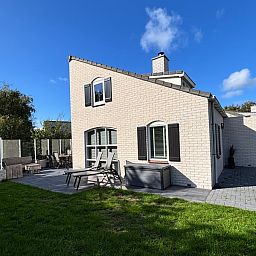 Das Ferienhaus F 561 in De Cocksdorp, Texel, bietet eine Sonnenterrasse und einen gruenen Garten zur Entspannung auf den Watteninseln.