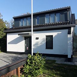 Vacation home E 525 in De Cocksdorp, Texel, offers a modern exterior with spacious garden, ideal for a relaxing stay on the Wadden Islands.