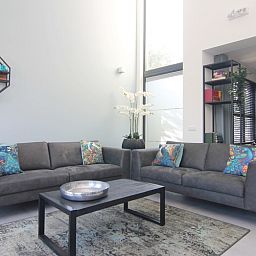 Modern living room in Holiday home E 525, De Cocksdorp, Texel. Comfortable sitting area with colorful cushions in a stylish vacation home.