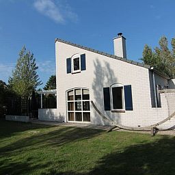 Das Ferienhaus F 713 in De Cocksdorp, Texel, bietet einen ruhigen Aussenbereich mit gruener Umgebung und einladender Architektur.