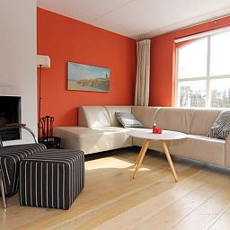 Gezellige woonkamer van Vakantiehuis E 634 in De Cocksdorp, Texel met comfortabele zithoek en grote ramen voor veel natuurlijk licht.