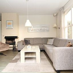 Gezellige woonkamer van Vakantiehuis E 409 in De Cocksdorp, Texel, met comfortabele zithoek en veel natuurlijk licht.