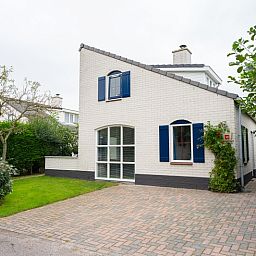 Vacation home E 541 in De Cocksdorp, Texel offers a charming exterior with a green garden and ample parking in the Wadden Islands.