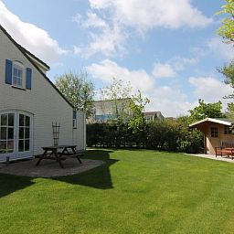 Vakantiehuis F 602 in De Cocksdorp, Texel, biedt een ruime tuin met terras en groene omgeving voor een ontspannen verblijf op de Waddeneilanden.