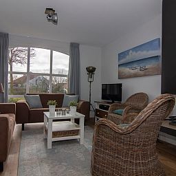 Gezellige woonkamer van Vakantiehuis F 602 in De Cocksdorp, Texel, met comfortabel interieur en uitzicht op de natuurlijke omgeving van de Waddeneilanden.