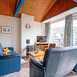 Gezellige woonkamer van Vakantiehuis Slufterhoek 110 in De Cocksdorp, Texel, met comfortabele zitplaatsen en uitzicht op de tuin.