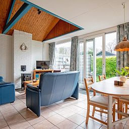 Gezellige woonkamer in Vakantiehuis Slufterhoek 110, De Cocksdorp, Texel. Licht interieur met comfortabele zithoek en uitzicht op de tuin.