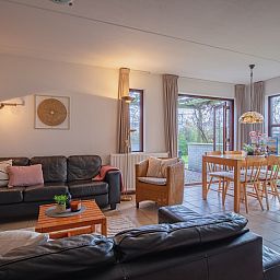 Gezellige woonkamer van vakantiehuis Annemein in De Cocksdorp, Texel. Geniet van het uitzicht op de natuur vanuit de comfortabele zithoek.