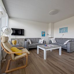 Gezellige woonkamer in Vakantiehuis Slufterhoek 080, De Cocksdorp, Texel, met comfortabele zithoek en moderne inrichting.