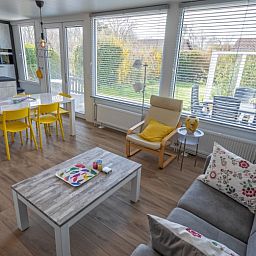 Gezellige woonkamer van Vakantiehuis Slufterhoek 080 in De Cocksdorp, Texel met uitzicht op de tuin en veel natuurlijk licht.