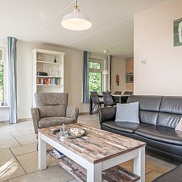 Stijlvolle woonkamer van Bungalow Klein Axel in De Cocksdorp, Texel, met comfortabele zithoek en veel lichtinval.