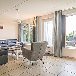 Ruime en lichte woonruimte in Bungalow Klein Axel, De Cocksdorp, Texel, met moderne inrichting en uitzicht op terras.