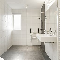 Bright living room with dining area in Sluftervallei bungalow, De Cocksdorp, Texel. Ideal for family gatherings.