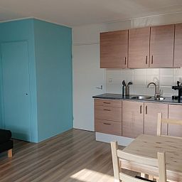 Moderne Kueche in der Ferienunterkunft Kikkerpoel, De Cocksdorp, Texel mit Holzschraenken und Geraeten.