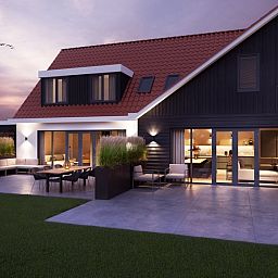 Avondzicht op 6 persoons vakantiewoning in De Cocksdorp, Texel met sfeervolle verlichting en moderne inrichting.