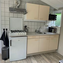 Moderne keuken in vakantiehuis Hoog Koog 12, Bungalowpark Hoog Koog, De Koog, Texel. Compleet met fornuis en magnetron voor comfortabel verblijf.