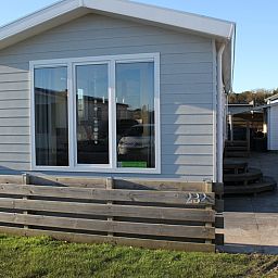 Chalet Bregkoog 232 in De Koog, Texel, biedt een uitnodigend terras en moderne uitstraling op het schilderachtige Chaletpark Bregkoog.
