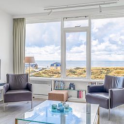Geraeumiges Wohnzimmer mit Blick auf die Duenen im Appartement Juliana 160 Zeezicht, De Koog, Texel. Perfekt fuer einen entspannten Aufenthalt.