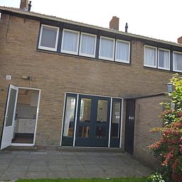 Achtertuin van vakantiehuis Watersnip in De Koog, Texel met terras en groen.