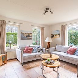 Gezellige zithoek in Vakantiehuis Kamperfoelie 81, De Koog, Texel, omringd door groen en voorzien van moderne meubels.