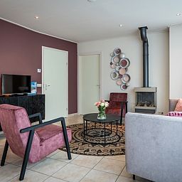 Moderne woonkamer van Bungalow 31a in De Koog, Texel met televisie en open haard.