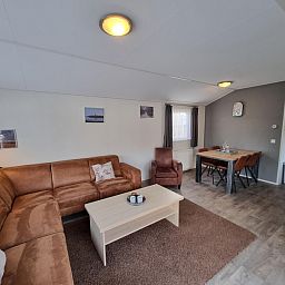 Sfeervolle eetkamer van Chaletpark Bregkoog - Chalet Bregkoog 235 in De Koog, Texel met houten tafel en stoelen.