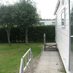 Geniessen Sie den ruhigen Garten auf Camping Coogherveld - Chalet Jori in De Koog, Texel. Entspannen Sie sich in der natuerlichen Umgebung dieses Ferienhauses.