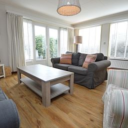 Gezellige woonkamer van vakantiehuis Kierewiet in De Koog, Texel, met comfortabele zithoek en veel natuurlijk licht.