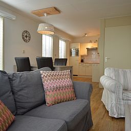 Gezellige woonkamer van vakantiehuis Kierewiet in De Koog, Texel, met comfortabele zithoek en moderne keuken voor een ontspannen verblijf.