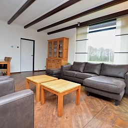 Stijlvolle woonkamer van Orchismient 28 vakantiehuis Texel met houten meubels.