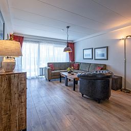 Ruime zithoek in Appartementen Anna - de Zeehond, De Koog, Texel met veel natuurlijk licht en moderne inrichting.