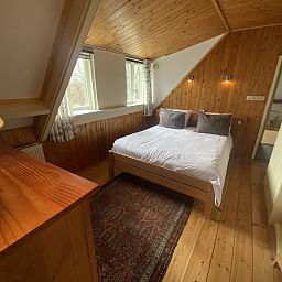 Sfeervolle slaapkamer in Voorhuis vakantiehuis, De Koog, Texel met houten interieur en natuurlijk licht.