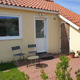 Gemuetliche Terrasse von De Duinpan - Duinhuisje Texel in De Koog, Texel, mit bequemen Sitzgelegenheiten.