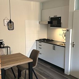Kompakte Kueche im Apartment Kerckeland 40, De Koog, Texel mit Essecke und modernen Geraeten.