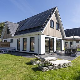 Villa 19, vacation accommodation in De Koog, Texel with spacious garden and deck chairs for relaxation.
