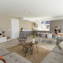 Open kitchen and dining area in Villa 19, a vacation home in De Koog, Texel, with modern furnishings.