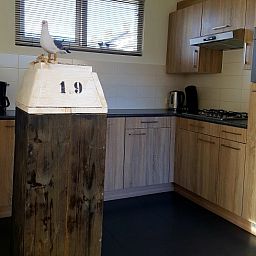 Volledig uitgeruste keuken in vakantiehuis De Anemoon, De Koog, Texel. Stijlvol design met houten kasten.