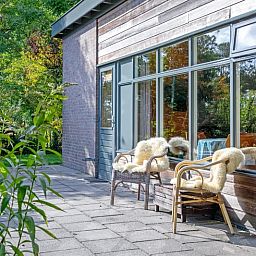 Zonnig terras bij De Zonneweelde vakantiehuis in De Koog, Texel, omringd door natuur.