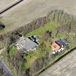 Luchtfoto van vakantiehuis Achterhuis in De Koog, Texel, met ruime groene omgeving.