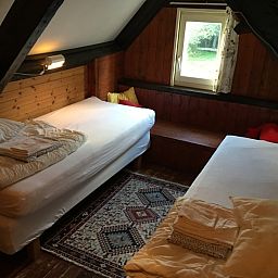 Knusse tweepersoonskamer in vakantiehuis Achterhuis, De Koog, Texel, met houten interieur.