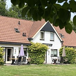Gezellige woonkamer van Koetshuis vakantiehuis in De Koog, Texel met comfortabele banken en uitzicht op de natuur van de Waddeneilanden.