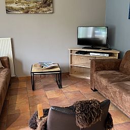 Gezellige woonkamer in Koetshuis vakantiehuis, De Koog Texel, met comfortabele zithoek en rustieke inrichting op de Waddeneilanden.