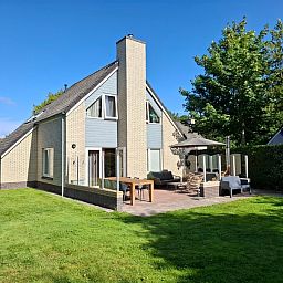 Terrasse und gruene Umgebung im Ferienhaus Honeysuckle 33 in De Koog, Texel.