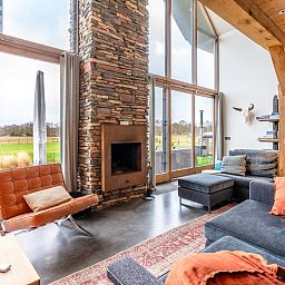 Cozy living room of Villa 191 with Hot tub in De Koog, Texel, with fireplace and views of nature.