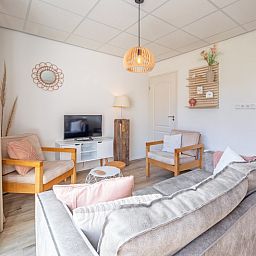 Stijlvolle zithoek in De Duinroos, Texel, met moderne inrichting en natuurlijke lichtinval.