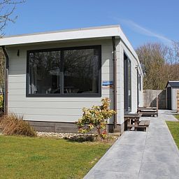 Chalet Bregkoog 208, een gezellig vakantieverblijf in De Koog, Texel, met een moderne uitstraling en omringd door groen.